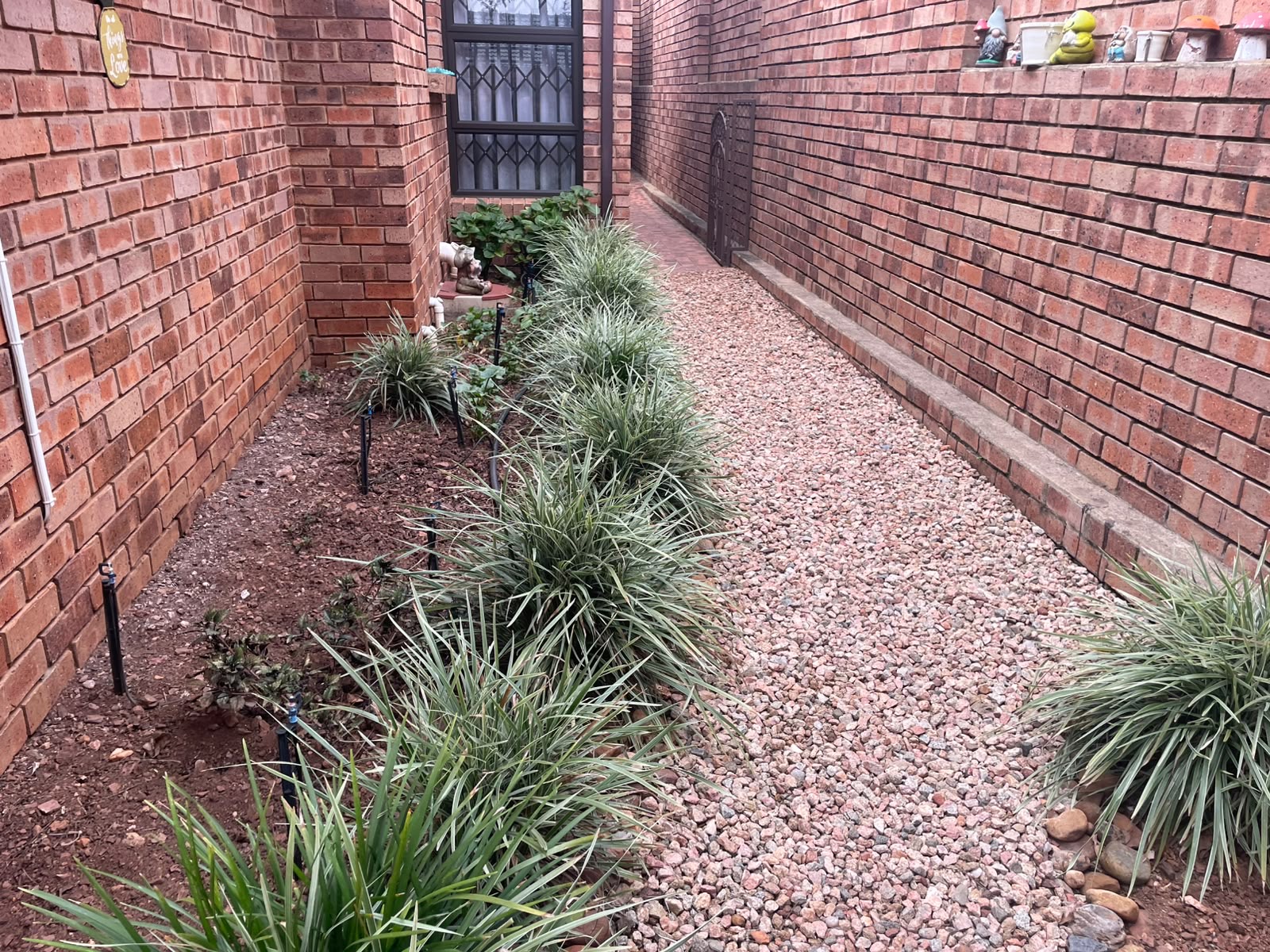 Narrow side passage — from gravel strip to full paving — before