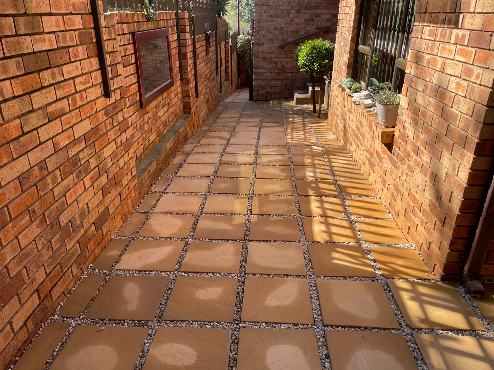 Overgrown pebble walkway to crisp tiled passage — after